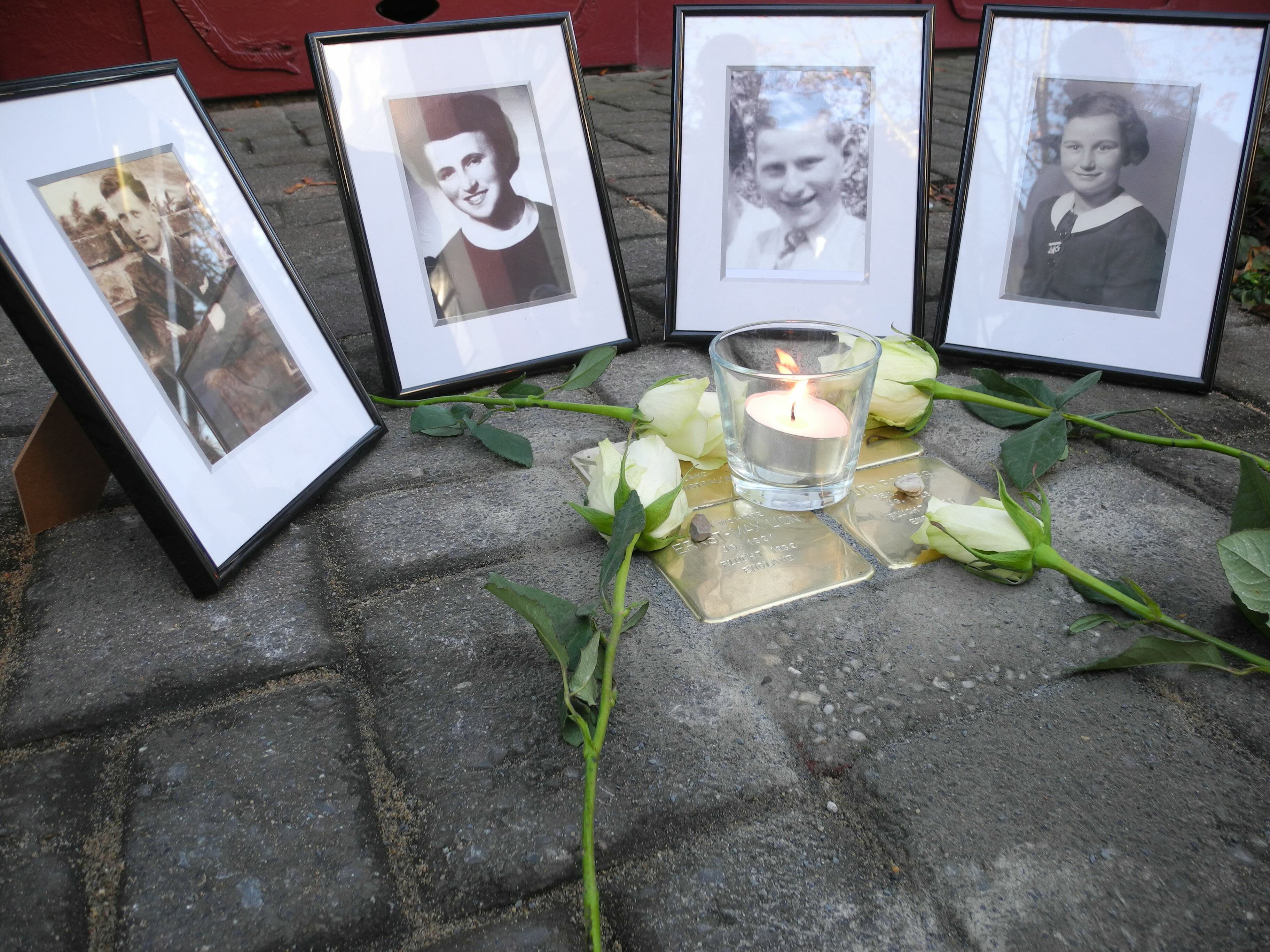 Stolpersteine mit Fotografien und Rosen