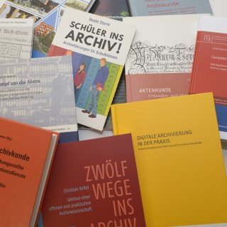 Mehrere bunte Bücher zum Thema "Archiv". 