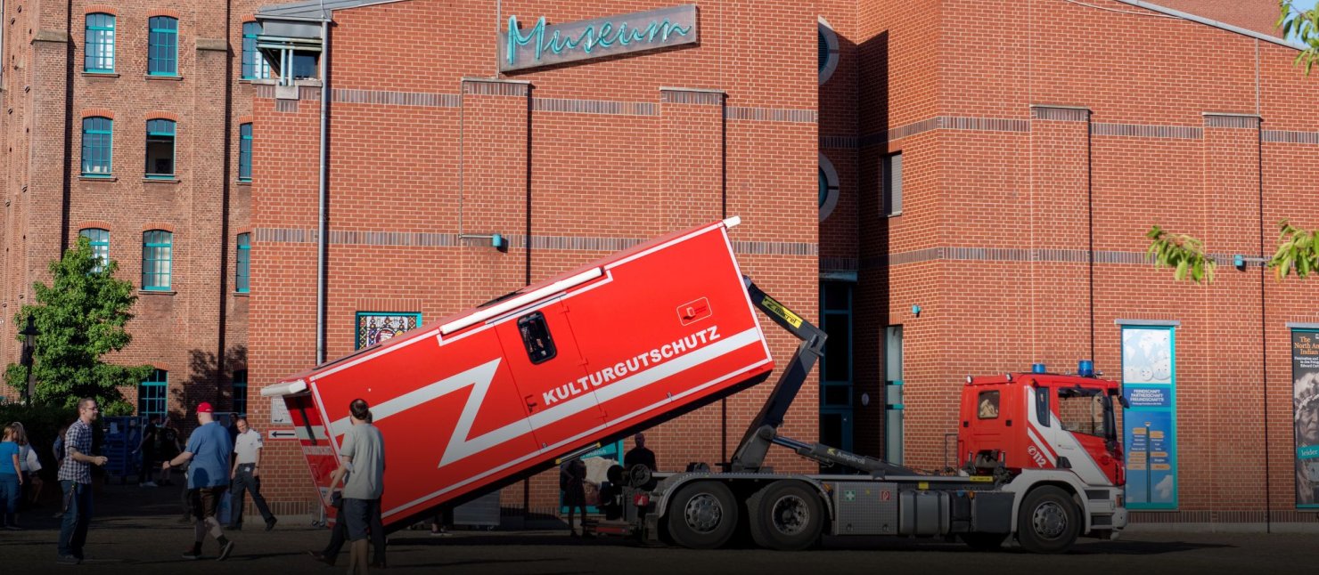Notfallcontainer Notfallconatiner wird von einem Feuerwehrauto vor dem Stadtarchiv Duisburg abgeladen