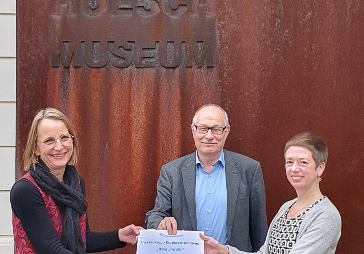 Astrid Dörnemann vom thyssenkrupp Corporate Archives überreicht Isolde Parussel, Leiterin des Hoesch-Museums, und Dr. Karl Lauschke, Vorsitzender des Fördervereins "Freunde des Hoesch-Museums", die Digitalisate der Werkzeitschrift „Werk und Wir“