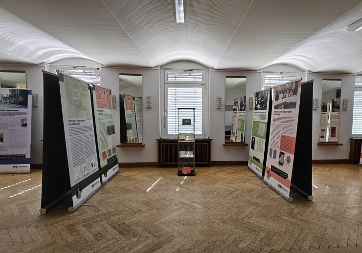 Eine Ausstellungsvitrine umgeben von Ausstellungsroll-Ups.