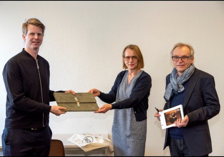 Frederik Hoffmann (links) überreicht eine Laptoptasche aus der Kollektion "august&alfred" an Astrid Dörnemann und Andreas Zilt von thyssenkrupp Corporate Archives
