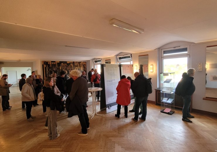 Eine Gruppe von Menschen schaut sich die Ausstellung an.