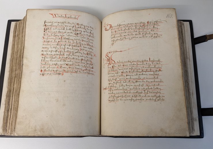 Aufgeschlagenes Buch mit handschriftlichem Text