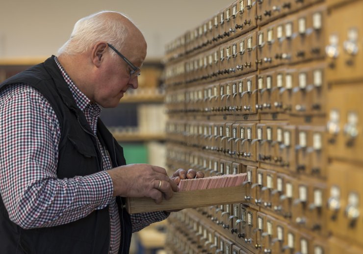 Ein Familienforscher im Lesesaal der Abteilung OWL bei der Benutzung der Kirchenbuchkartei, welche die in den lippischen Kirchenbüchern genannten Namen recherchierbar macht.