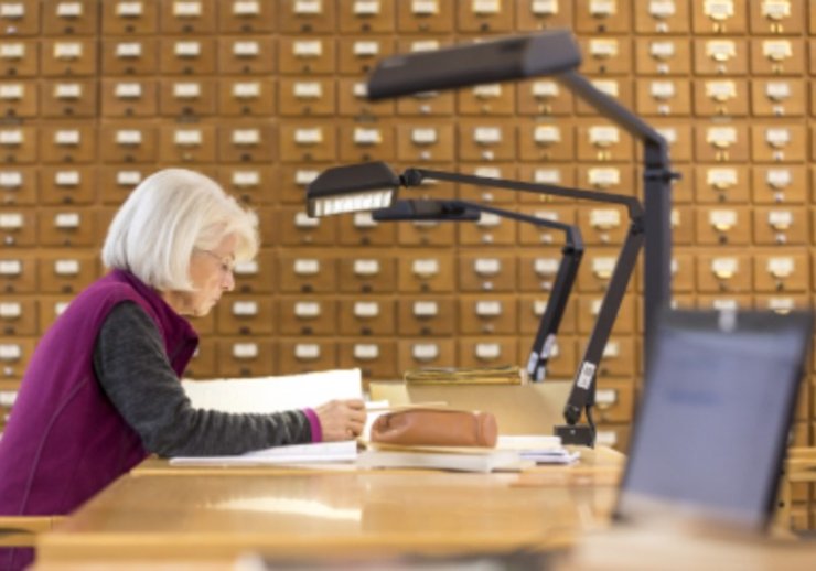 Eine Benutzerin im Lesesaal der Abteilung OWL studiert Archivgut. 