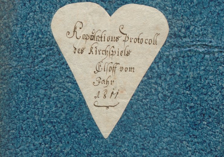 Ein blauer Aktendeckel mit einem weißen Herz in der Mitte. Darauf geschrieben steht: Kopulations-Protocoll des Kirchspiels Elsoff vom Jahr 1811